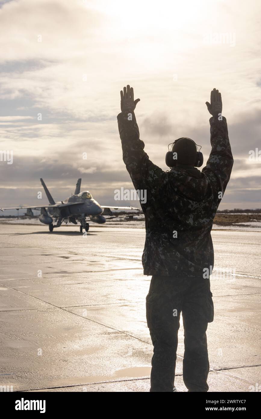 Un agent de maintenance de l'armée de l'air finlandaise, à droite, envoie des signaux mains et bras à un pilote F/A-18C Hornet de l'armée de l'air finlandaise Banque D'Images