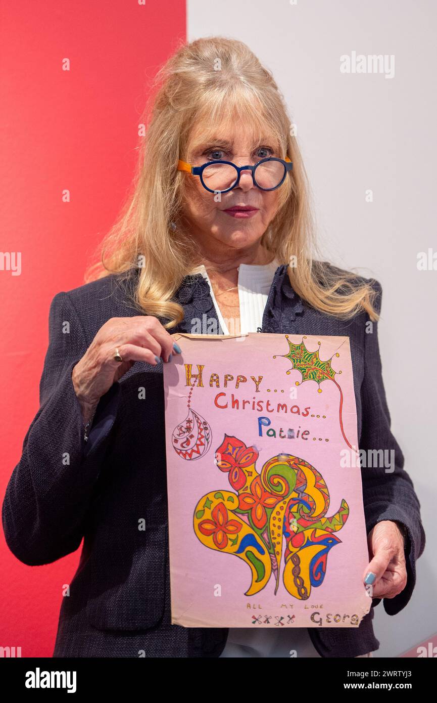 Londres, Angleterre, Royaume-Uni. 14 mars 2024. Modèle, photographe et icône PATTIE BOYD détient une œuvre de Noël exécutée par George Harrison pour son circa 1968. La pièce comporte de l'encre noire et des stylos feutres multicolores sur une feuille de papier mauve, mettant en valeur un motif floral et folié tourbillonnant avec un lettrage ornemental indiquant « HAPPY. Noël. Pattie.', à côté de l'inscription 'All My Love, XXXX George' dans l'écriture manuscrite de Harrison au verso, avec le message supplémentaire 'To Pattie, with Love from George, Christmas xx' (crédit image : © Thomas Krych/ZUMA Press Wire) USAGE ÉDITORIAL SEULEMENT! Non Banque D'Images