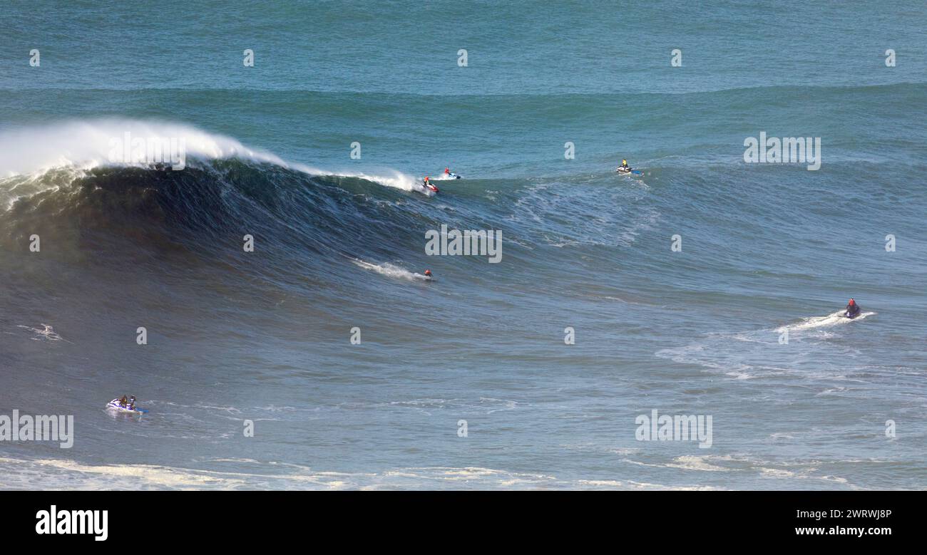 Europe, Portugal, région d'Oeste, Nazaré, Surfer et support Jet skis à cheval sur d'énormes vagues près de Praia do Norte pendant l'événement de surf gratuit 2022 Banque D'Images