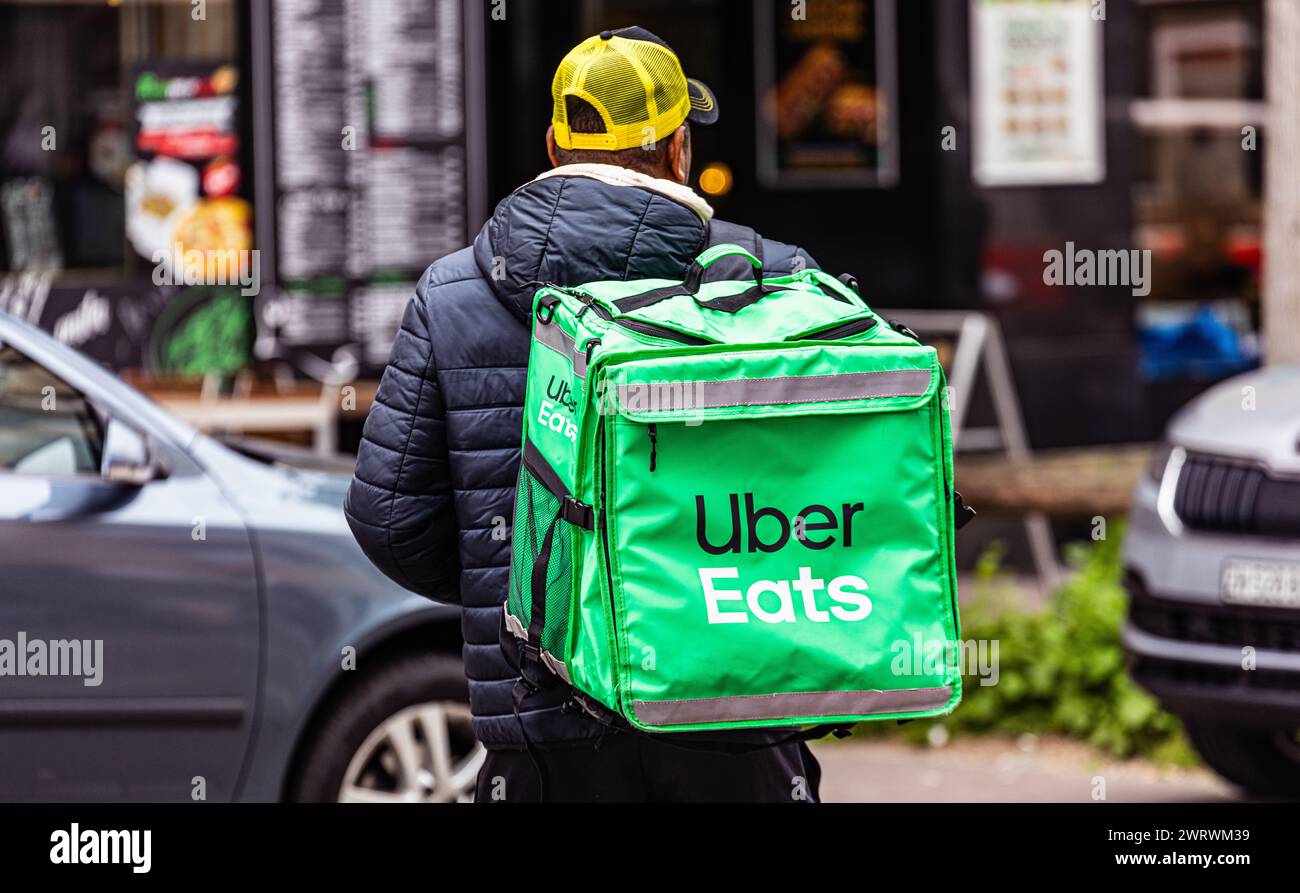 Eine erwachsene person ist für den Essenlieferdienst UberEats damit beschäftigt Esswaren zu den Kunden zu liefern. (Zürich, Schweiz, 20.05.2023) Banque D'Images