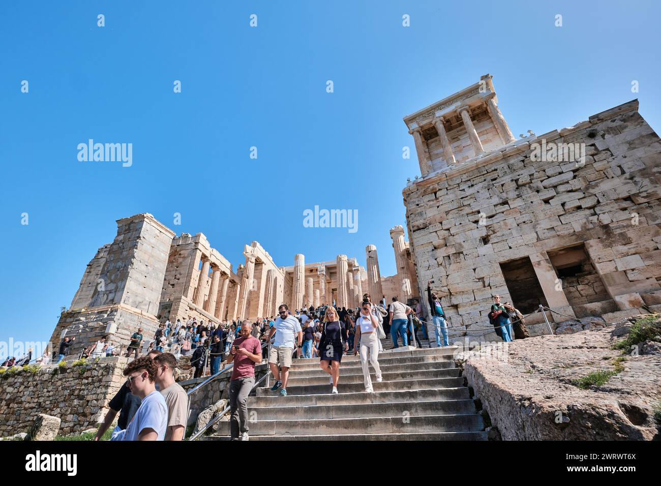 Athènes, Grèce - mars 02, 2024 : vue des visiteurs et Temple d'Athéna Nike Propylaea ancienne entrée Gateway ruines Acropole Banque D'Images