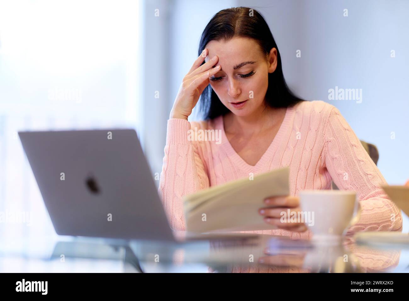 Femme inquiète à la recherche de ses factures Banque D'Images