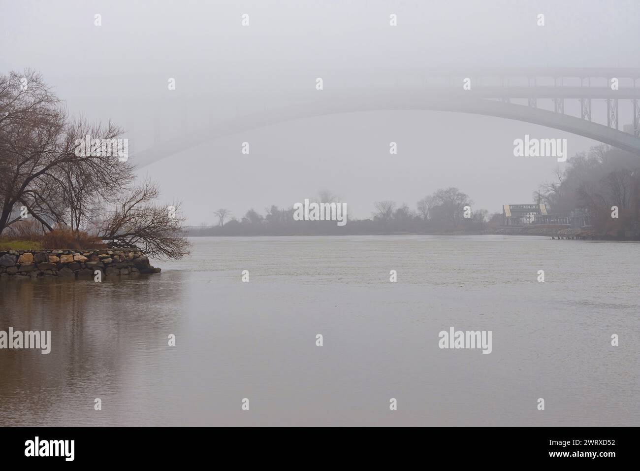 Une scène brumeuse au-dessus du ruisseau Sputin Duyvil au large de la rivière Hudson avec l'arc du pont Henry Hudson jetant un coup d'œil hors du brouillard, espace copie Banque D'Images