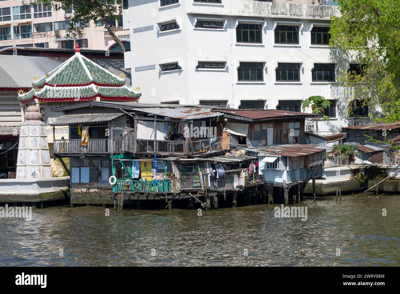 Vieux bâtiments sur pilotis sur la rivière Chao Phraya, Bangkok, Thaïlande. Banque D'Images