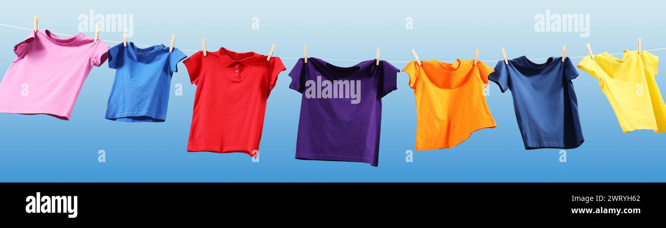T-shirts colorés séchant sur la ligne de lavage contre le ciel bleu, vue d'angle bas. Conception de bannière Banque D'Images T-shirts colorés séchant sur la ligne de lavage contre le ciel bleu, vue d'angle bas. Conception de bannière Banque D'Images