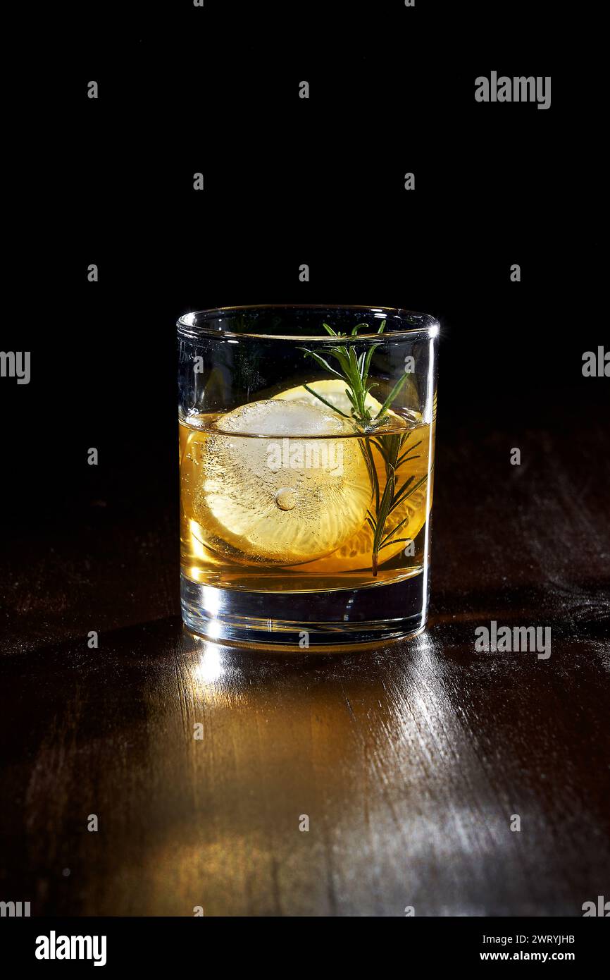 un verre de whisky avec citron et glace Banque D'Images