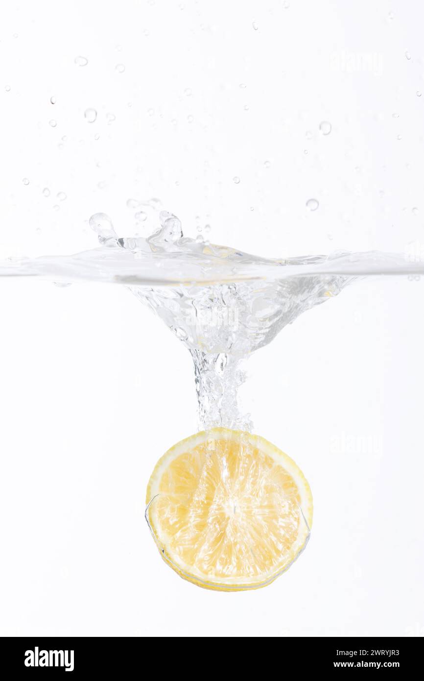 la moitié d'un citron tombant dans l'eau Banque D'Images