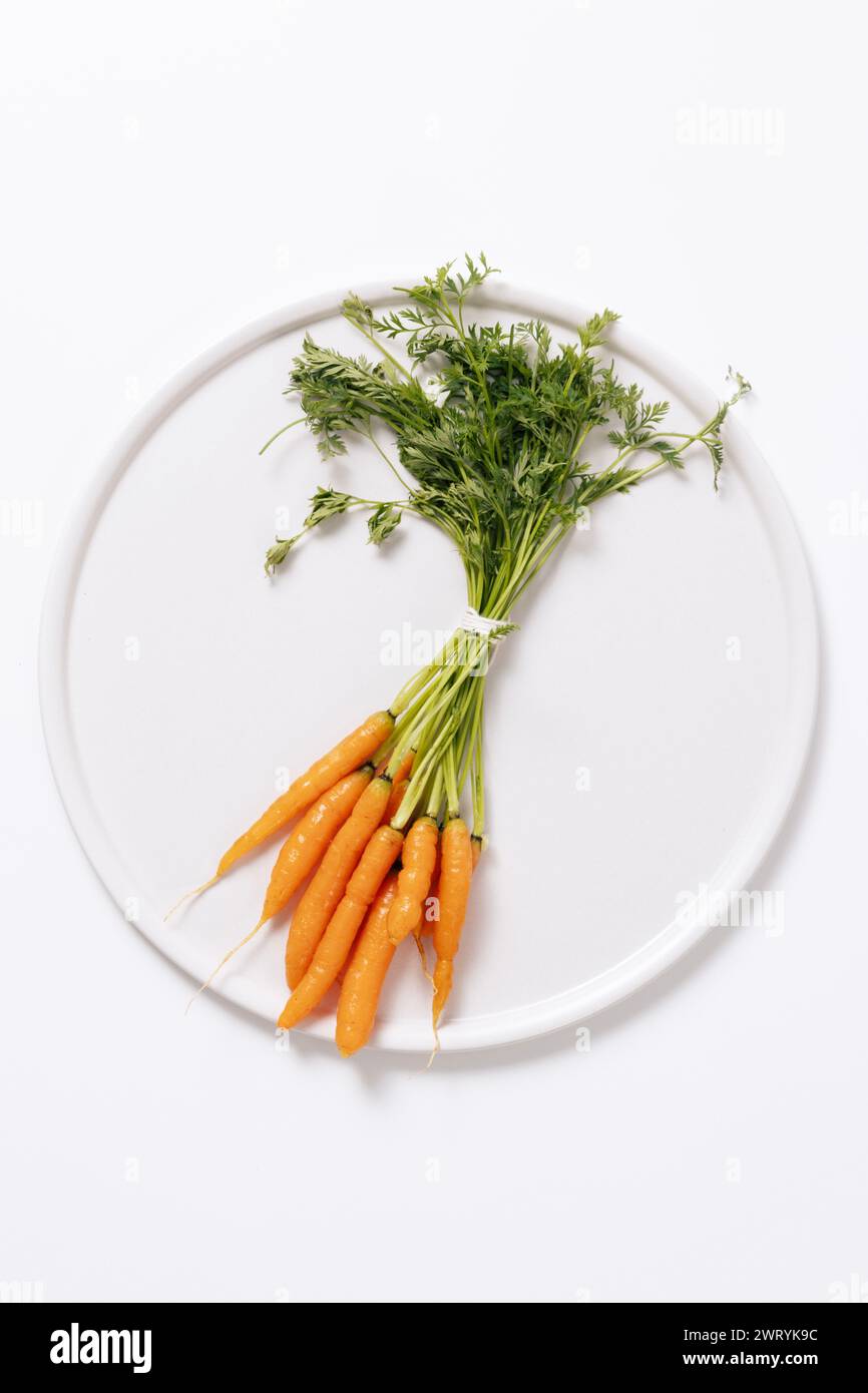 Mini carotte sur une assiette blanche Banque D'Images