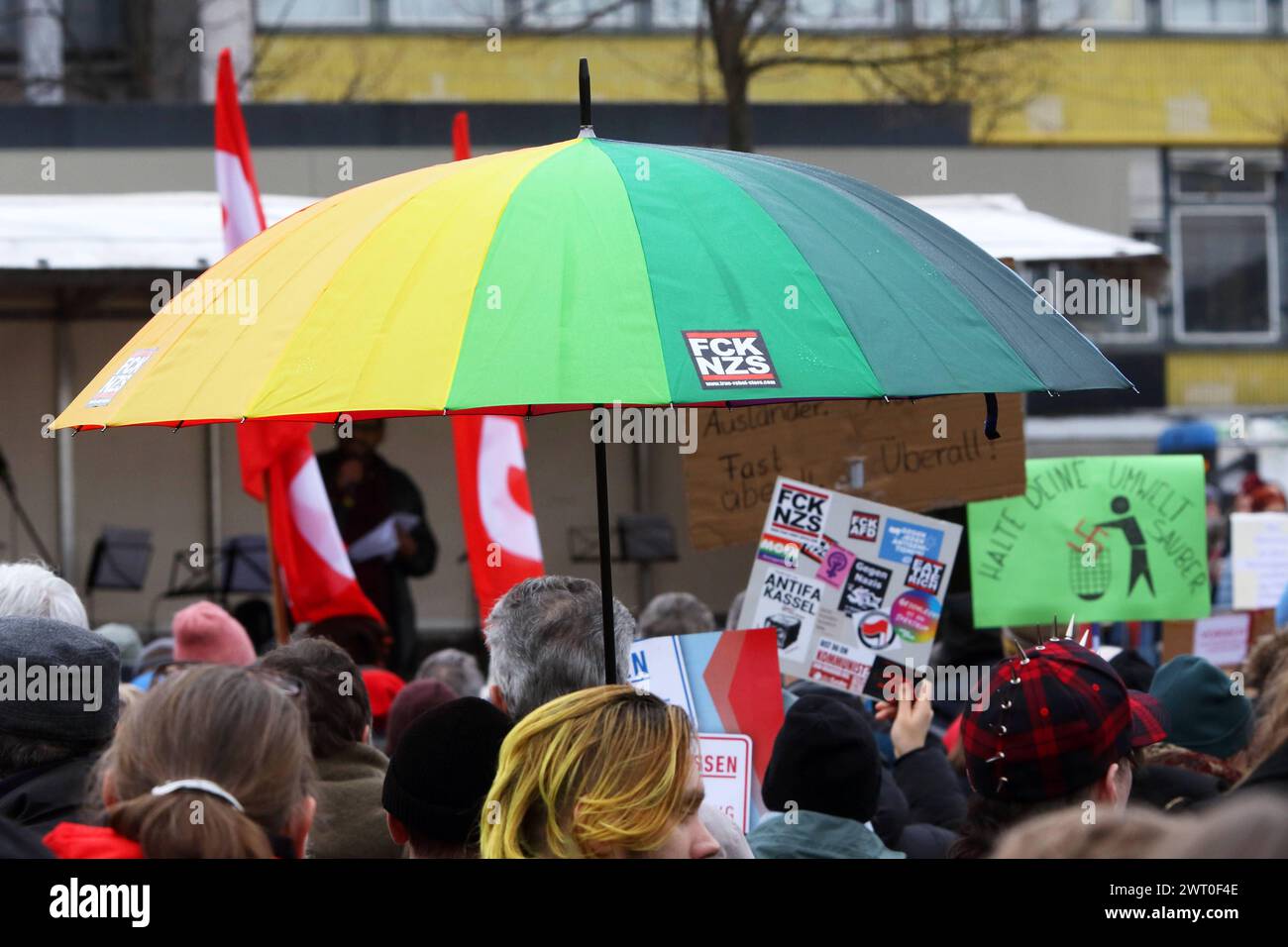 Main dans la main Kundgebung für eine offene, demokratische und vielfältige Gesellschaft in Kassel - Gegen rechten Terror in Deutschland - Deutschland, GER, DEU, Allemagne, Kassel, 03.02.2024 - Tausende Menschen demonstrieren auf dem Friedrichsplatz in der Innenstadt von Kassel gegen rechte Tendenzen in Deutschland. Hauptauslöser der zahlreichen Demonstrationen in ganz Deutschland gegen die AFD sind die Recherchen von CORRECTIV Recherchen für die Gesellschaft gemeinnützige GmbH. Bunter Regenschirm : FCK - NZS - www.true-rebel-store.com - Demoschild : HALTE DEINE UMWELT SAUBER - Figur tut rotes Hakenkre Banque D'Images
