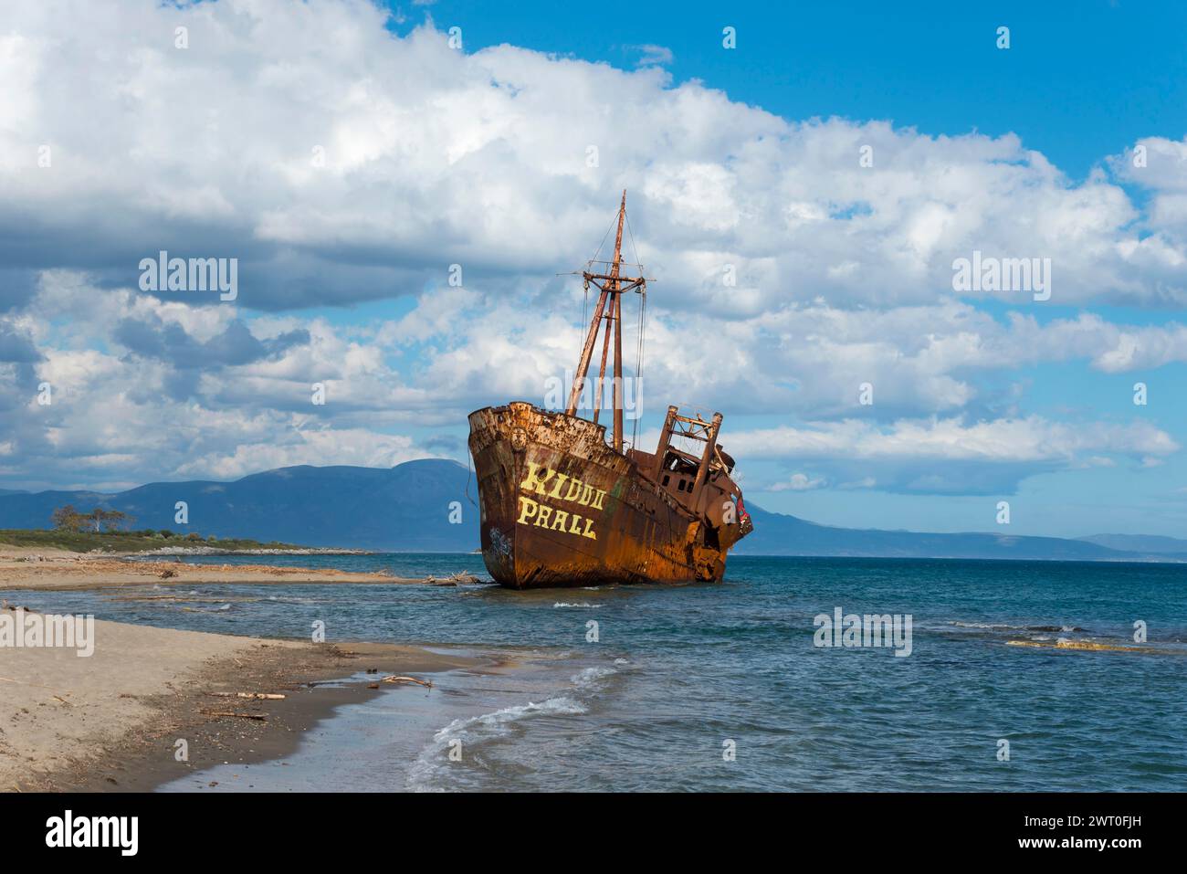 La proue d'un navire rouillé mange dans la plage de sable contre un ciel bleu et des nuages moelleux, naufrage Dimitrios, plage de Glyfada, Selinitsa, Gythio Banque D'Images