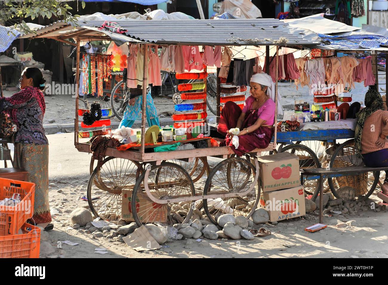 Femmes vendant des vêtements dans un étal coloré de marché extérieur, Bhairahawa, Pokhara, Népal Banque D'Images