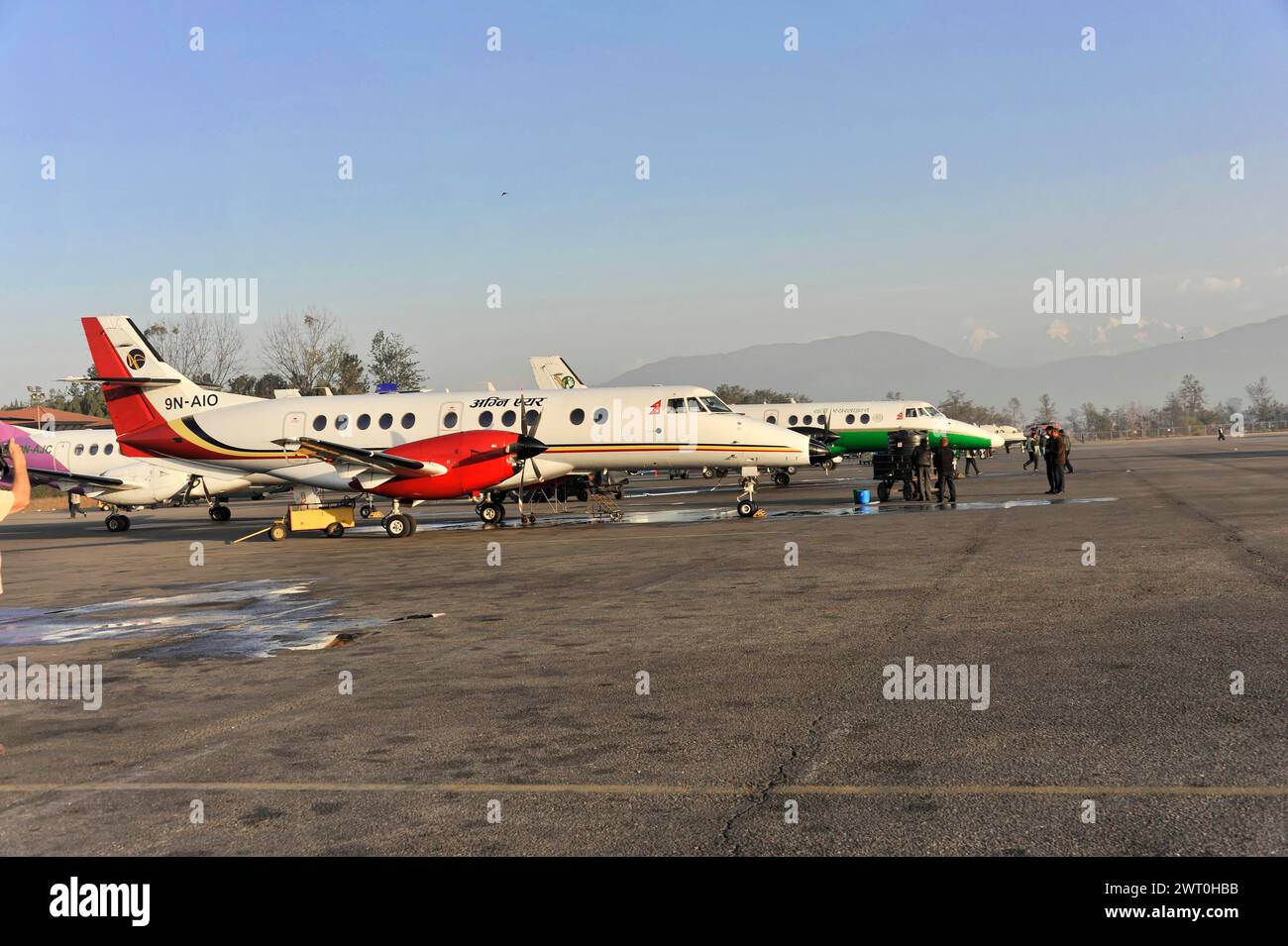 Plusieurs avions stationnés et des gens à un aéroport, impressions du grand vol panoramique le long des géants de l'Himalaya, le toit du monde Banque D'Images