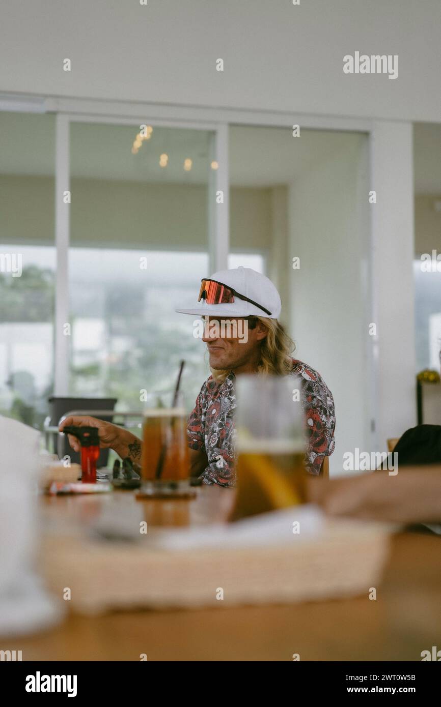 Un homme aux longs cheveux blonds dans un café. Banque D'Images