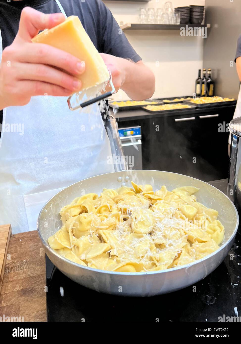 Ajouter le parmesan râpé final au plat de pâtes Banque D'Images