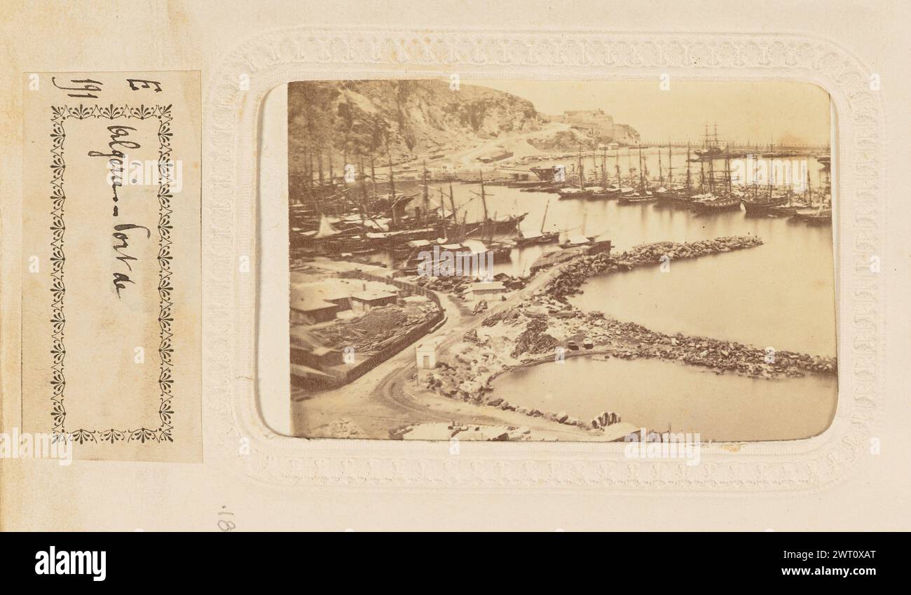 Port de Algerie. Joseph Augustin Pedra, photographe (algérien, 1809 - 1879) à propos de 1870 vue d'en haut sur le port d'Algérie. Il y a trois ports apparents divisés par des murs de pierre. Deux rangées de navires sont amarrées dans un port. (Verso, monture) en haut à gauche, encre noire : '[illisible]' ; en haut à droite, encre noire : 'O[illisible] M.M. O.' ; (recto, page d'album) en bas au centre, au-dessous de l'image, encre noire sur étiquette de papier blanc : 'E/191 [Space] Algérie.-Port de'; Banque D'Images