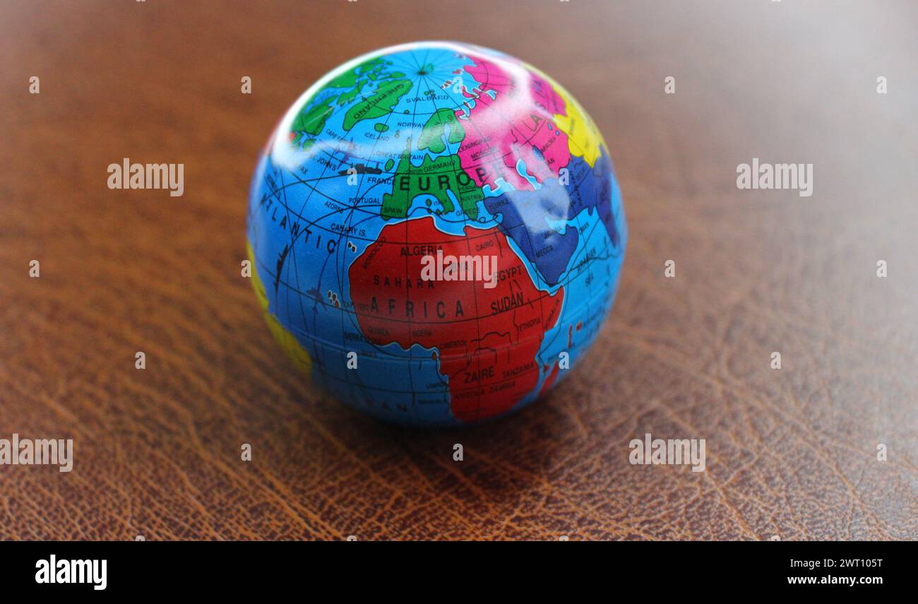 Modèle de la sphère terrestre avec les principales routes de transport entre les continents cartographié sur la table en cuir Banque D'Images