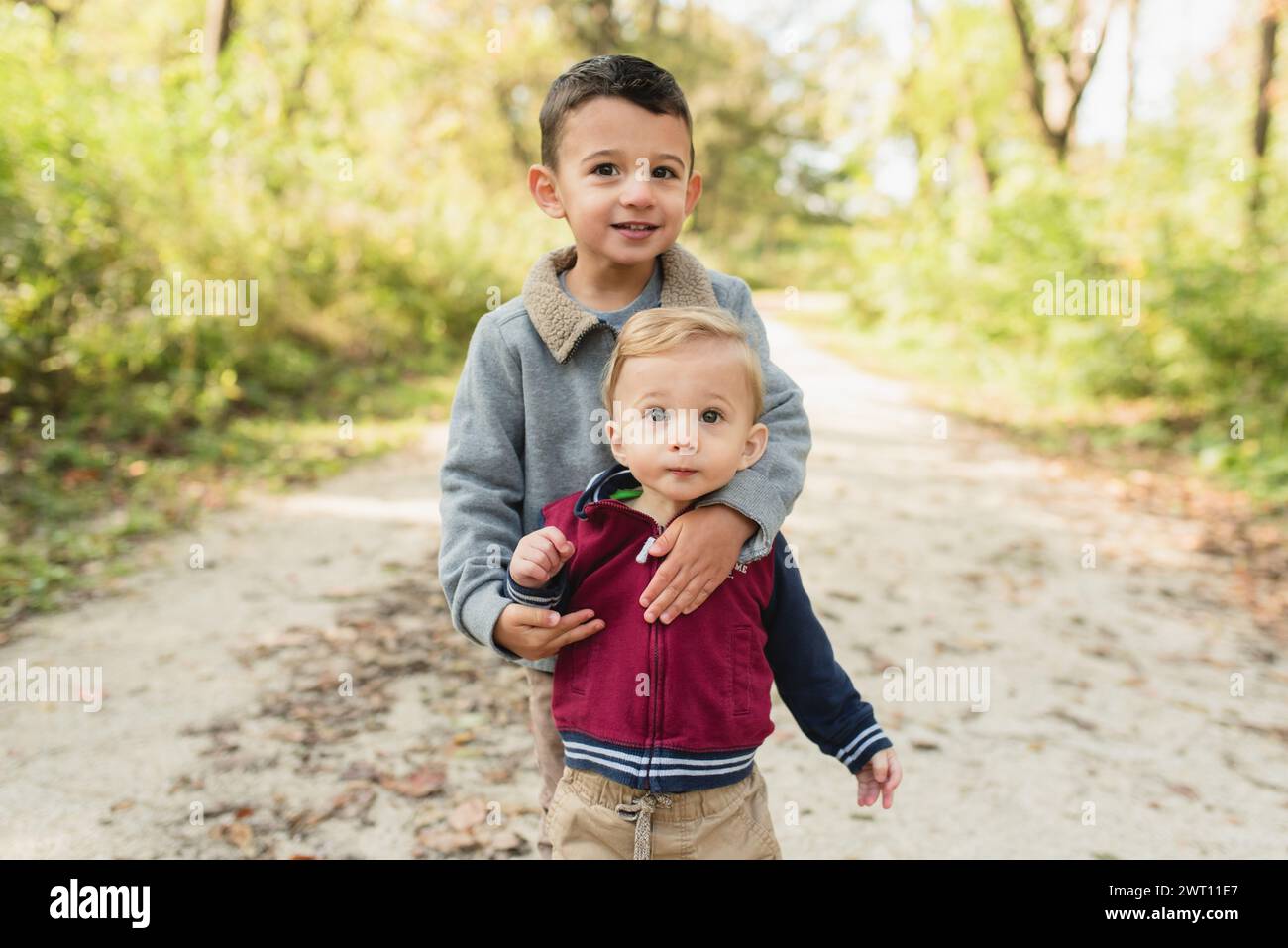 Portrait de deux jeunes enfants souriants et serrés dans la forêt Banque D'Images