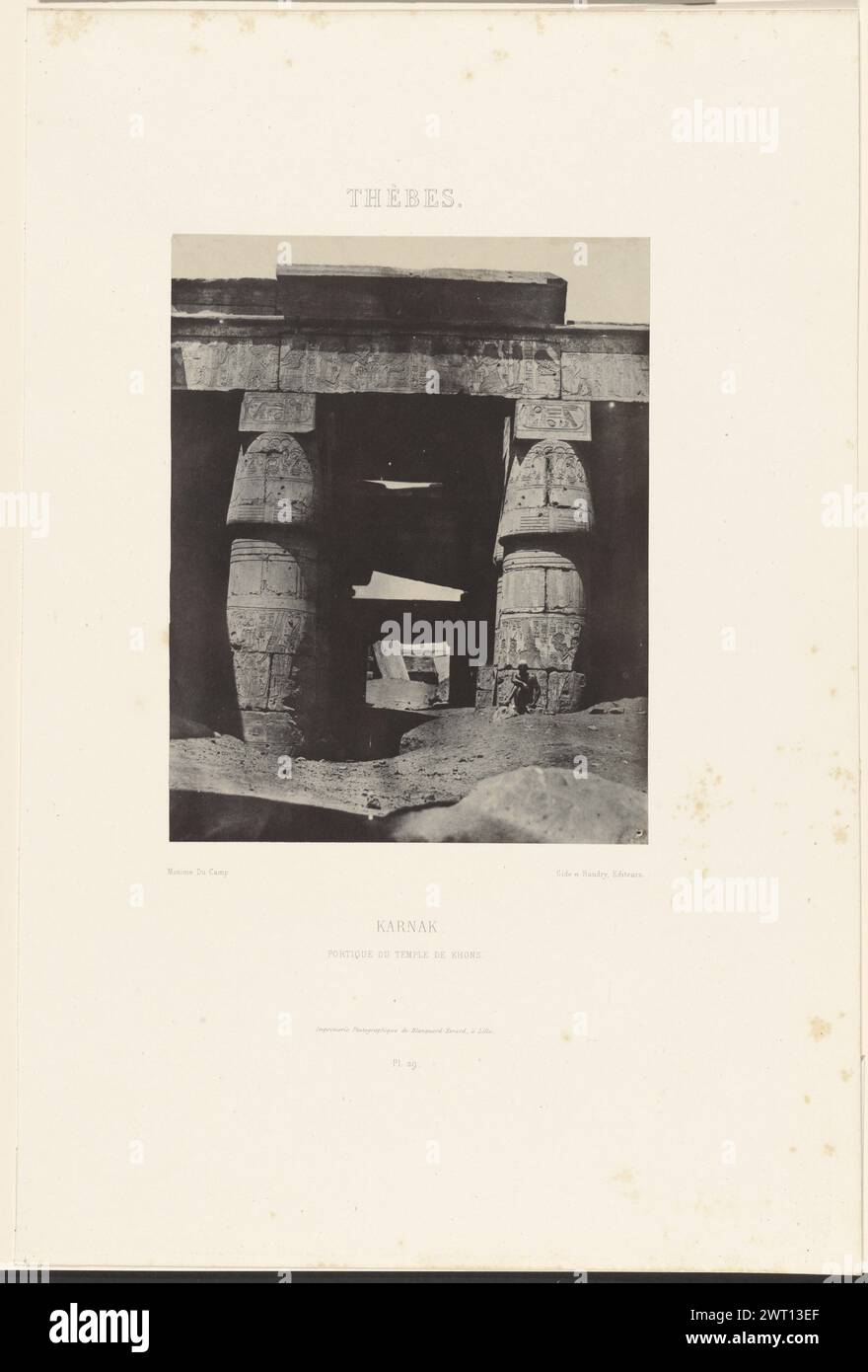 Thèbes. Karnak. Portique du temple de Khons.. Maxime du Camp, photographe (français, 1822 - 1894) Louis désiré Blanquart-Evrard, imprimeur (français, 1802 - 1872) négatif 6 mai 1850, tirage 1852 Portail rectangulaire en pierre, sculpté de hiéroglyphes. Un homme est assis à la base du portail. Banque D'Images