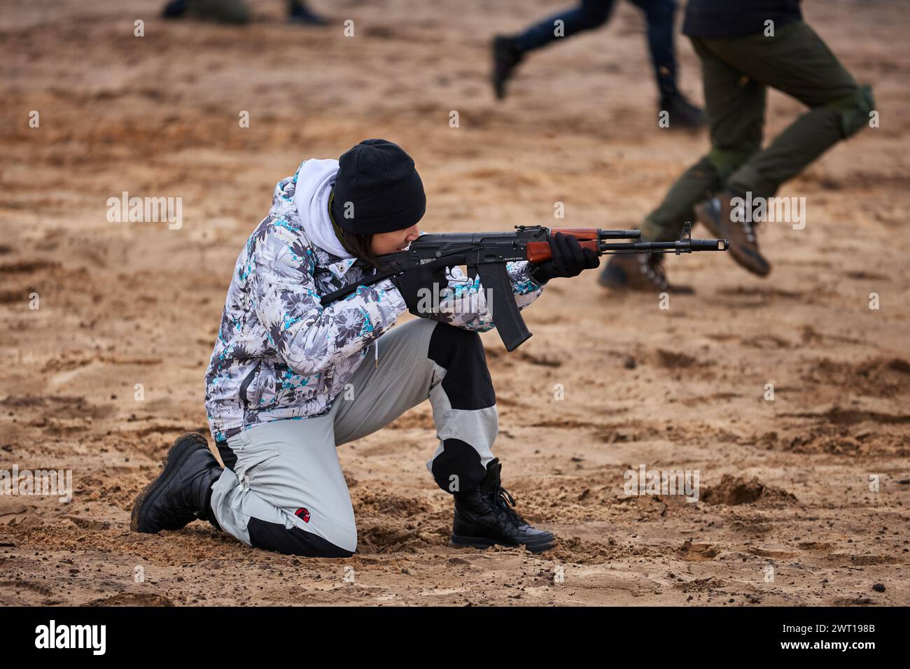 Jeune ukrainienne tirant avec un fusil depuis une position assise sur un polygone militaire. Kiev - 27 janvier 2024 Banque D'Images