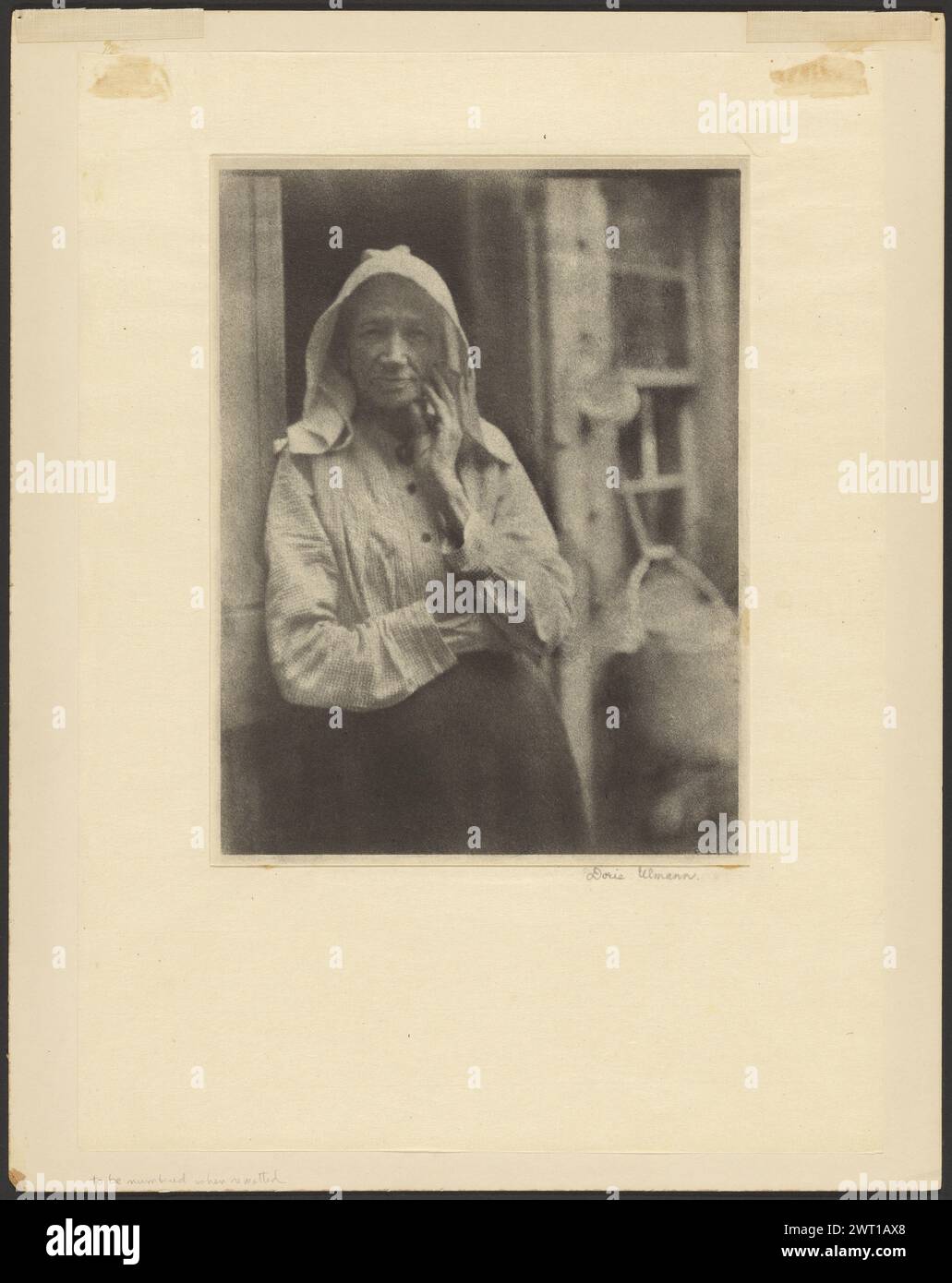 Il y a longtemps. Doris Ulmann, photographe (américaine, 1882 - 1934) 1918 Portrait debout de trois quarts de longueur d'une femme. Elle porte un couvre-chef blanc, une blouse à carreaux et une jupe sombre. Son bras droit est replié sur son ventre tandis que sa main gauche repose légèrement sur sa joue. (Verso, monture) en haut à gauche, au crayon rouge : '86 [latéralement]' ; en haut à gauche, au crayon bleu : '131' [croisé au crayon rouge, souligné au crayon brun] en haut à droite, à l'encre noire : 'Doris Ulmann / 129 West 86th Street / New York City / $25 / non. VI il y a longtemps longtemps' ; Centre, au crayon bleu : 'a' [encerclé] ; Centre, en bl Banque D'Images