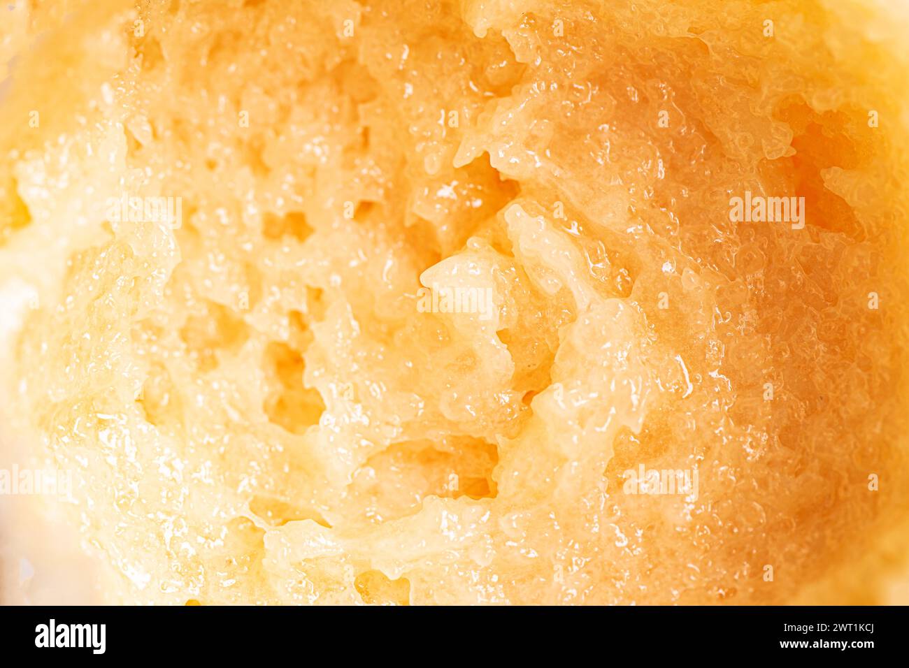 Test de gommage au sucre jaune frottis maculage gros plan. Texture du gommage corporel orange avec du sel ou du sucre. Banque D'Images