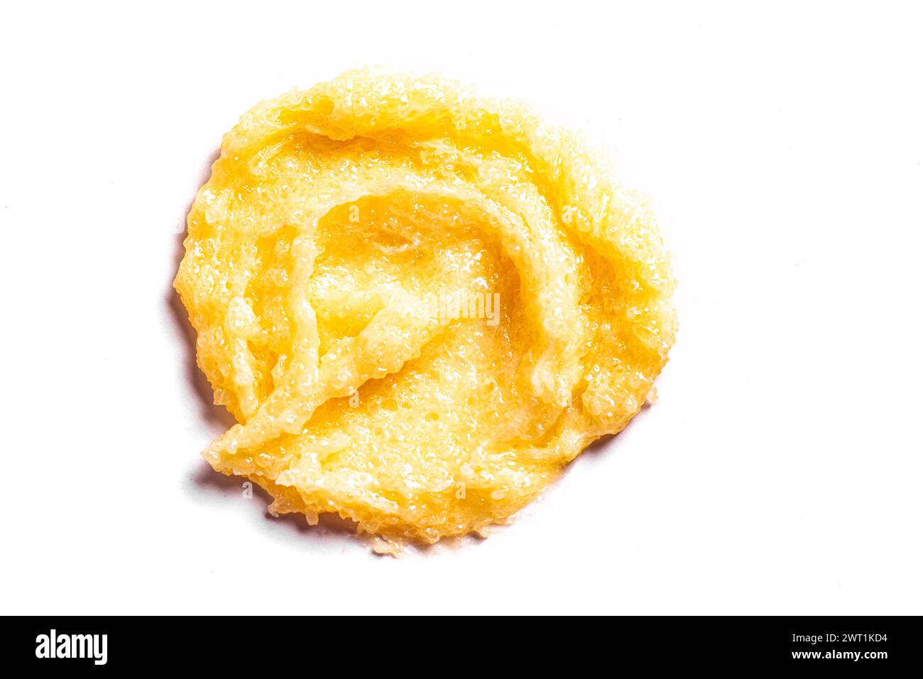 Maculage au sucre jaune maculage isolé sur fond blanc. Texture du gommage corporel orange avec du sel ou du sucre. Banque D'Images