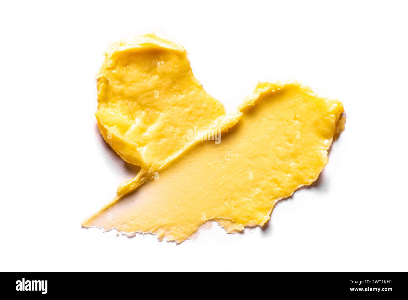 Maculage de crème cosmétique jaune isolé sur fond blanc. Coup de beurre de corps riche, produit cosmétique d'argile. Banque D'Images