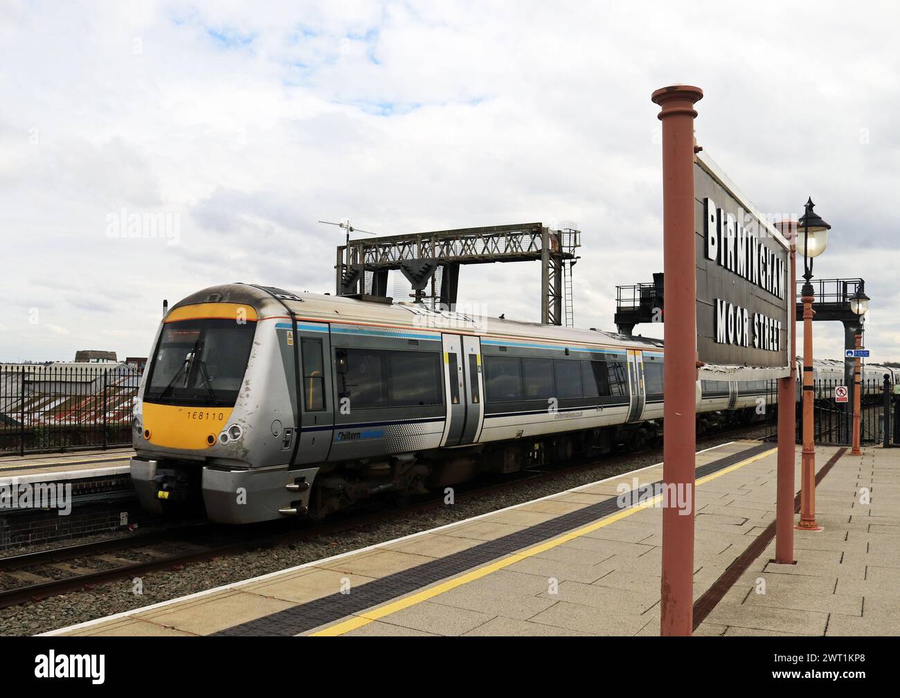 Un train Chiltern passant devant un vieux panneau en bois part de la gare de Birmingham Moor Street formant un service à Londres Marylebone. Banque D'Images