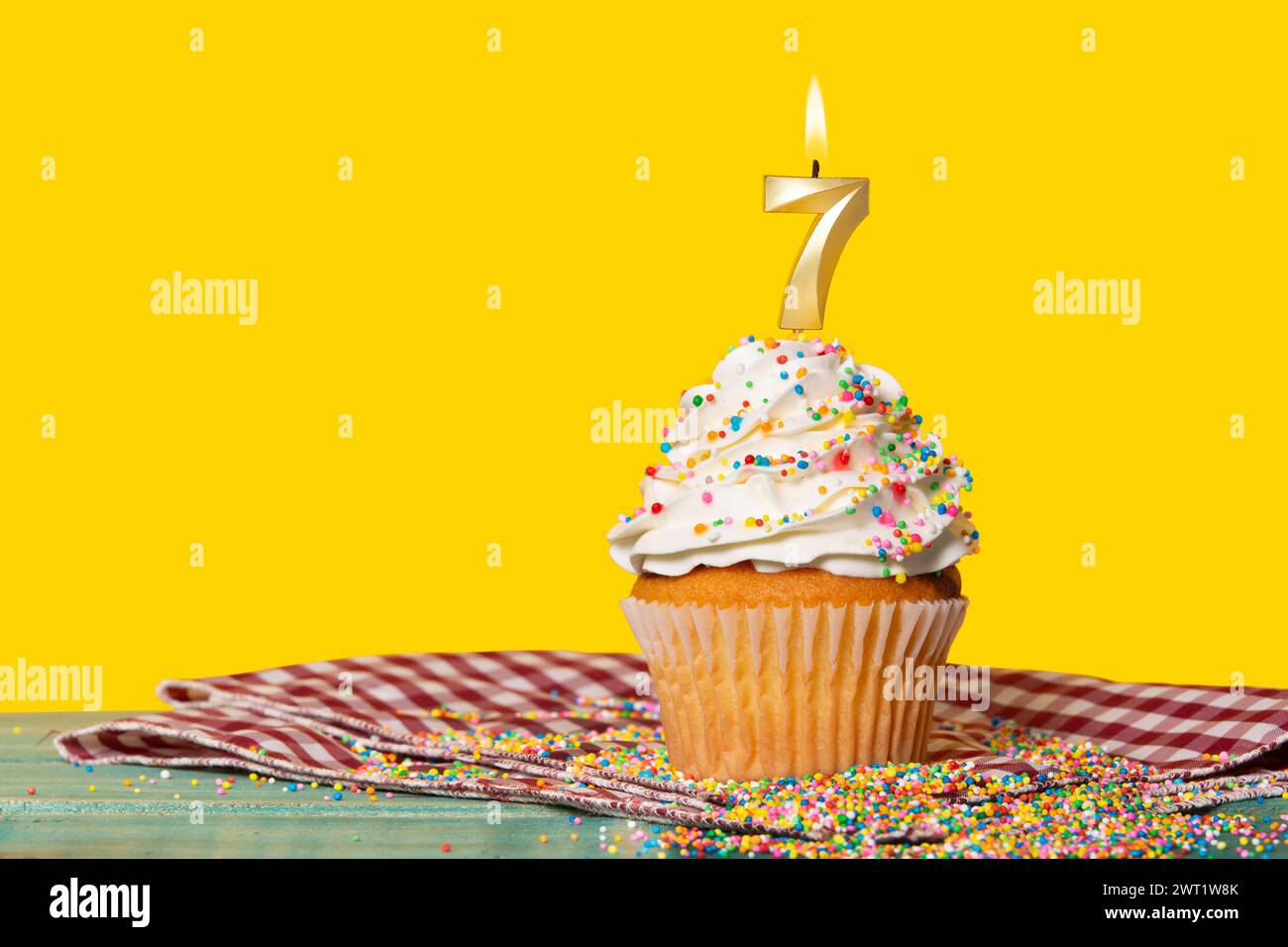Gâteau d'anniversaire avec bougie numéro 7 - photo sur fond jaune. Banque D'Images
