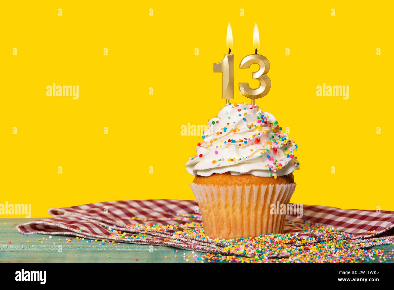 Gâteau d'anniversaire avec bougie numéro 13 - photo sur fond jaune. Banque D'Images