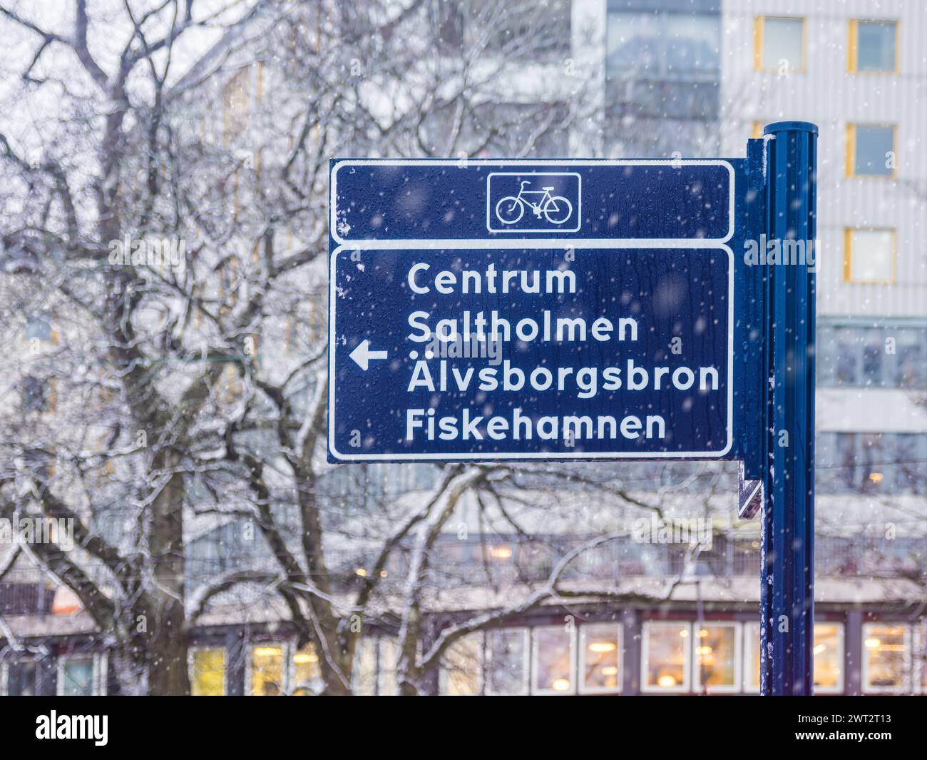 Un panneau de signalisation cycliste se tient résistant au milieu d'une douce chute de neige à Gothenburg, dirigeant les cyclistes vers Centrum, Salltholmen, Älvsborgsbron et Fiskeham Banque D'Images