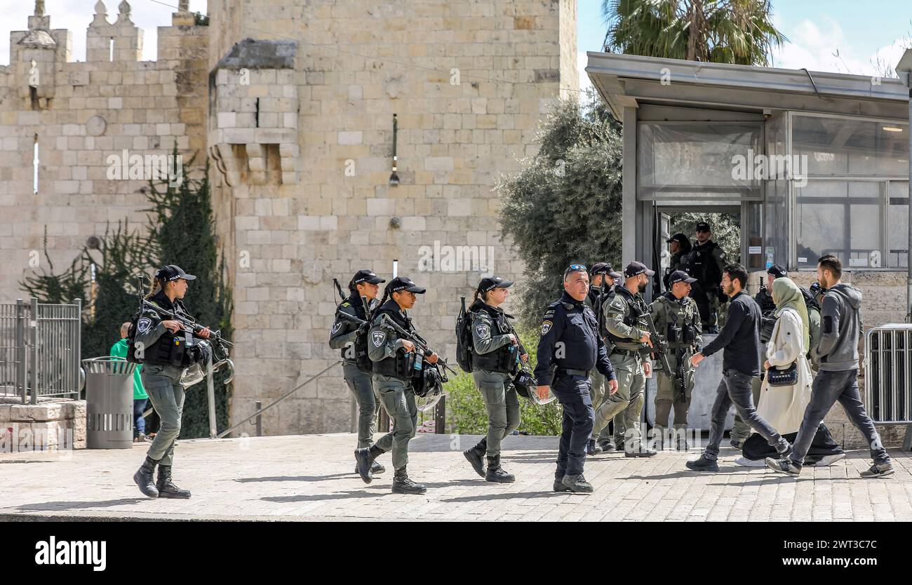 Policiers israéliens armés, policières et pèlerins palestiniens marchant près de la porte de Damas de la vieille ville de Jérusalem. En arrière-plan se trouvent les murs de la ville. Parmi les pèlerins se trouve une femme portant un hijab. Crédit : Yoram Biberman/Alamy Live News. Banque D'Images