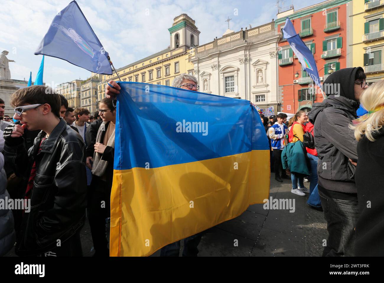 Un homme avec le drapeau de l'Ukraine, lors de la manifestation pour la paix en Ukraine, un an après l'invasion par la Russie. Banque D'Images