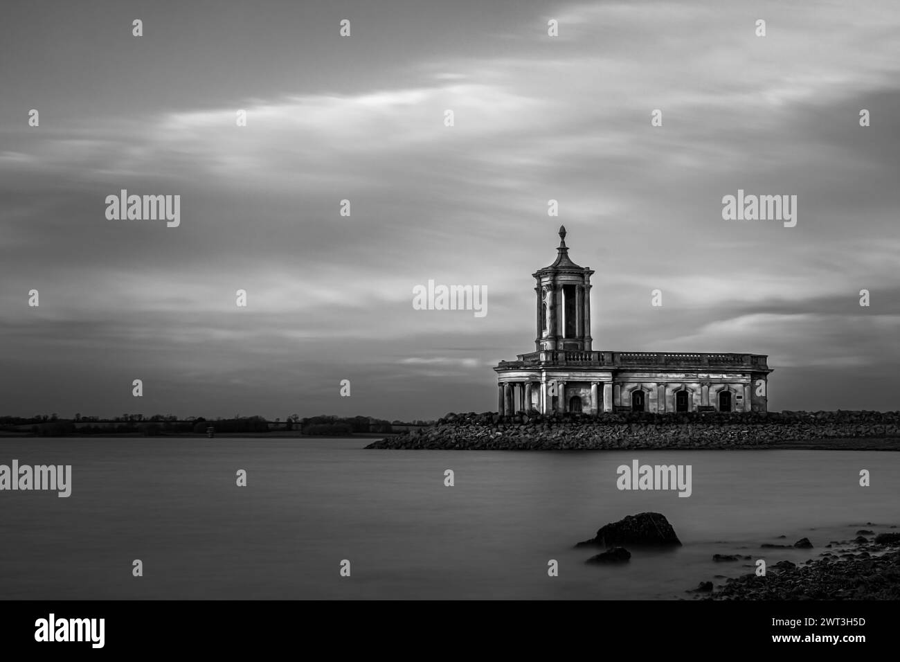 Normanton Church Rutland Water au coucher du soleil - le lieu idéal pour la photographie de mariage et la cérémonie - avec les nuages et le ciel éclairés par le soleil tardivement et l'eau lisse Banque D'Images