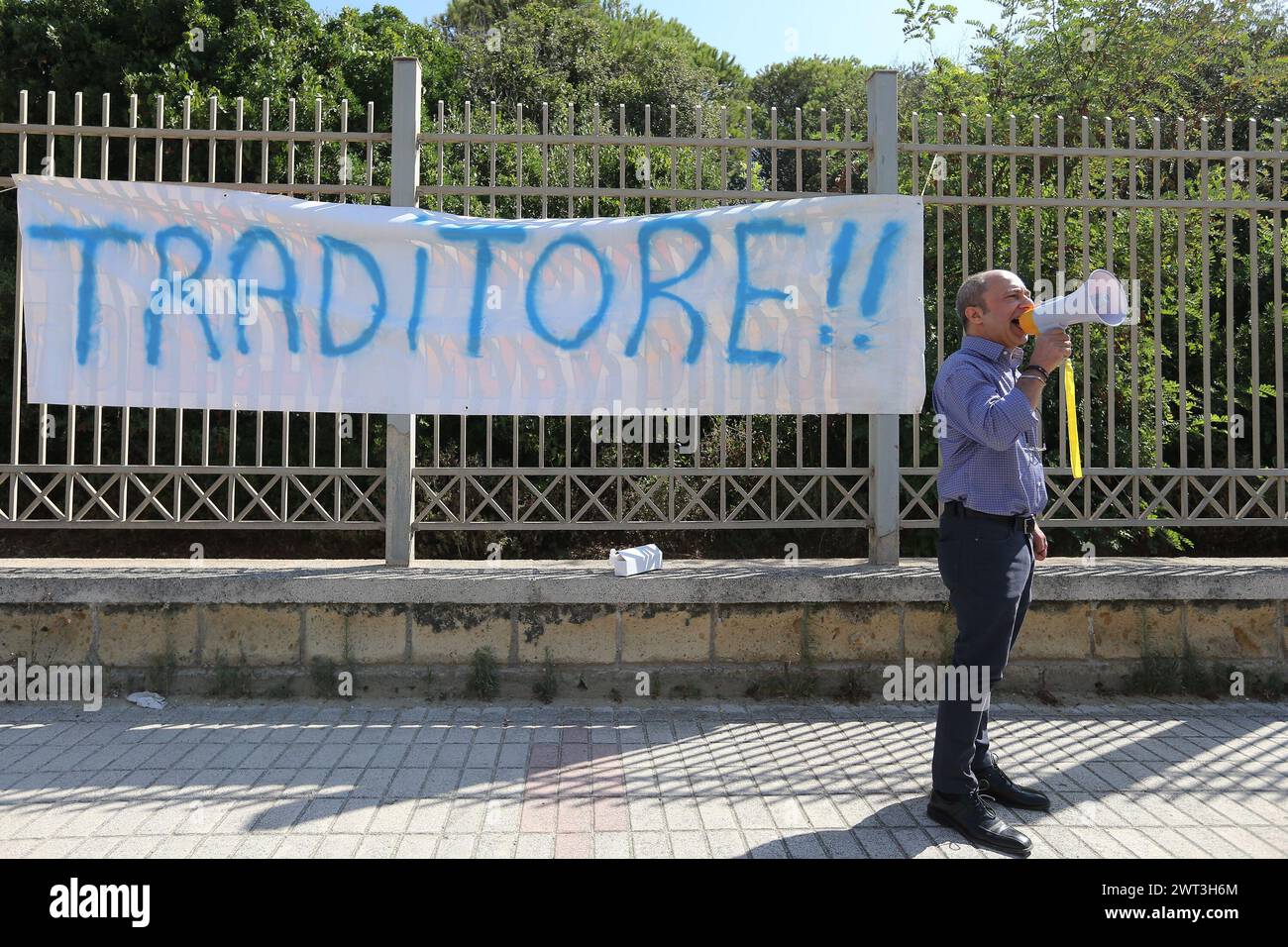 Un homme, avec un mégaphone, devant une banderole qui dit "traître", proteste contre l'arrivée du ministre de l'intérieur, Matteo Salvini, à th Banque D'Images