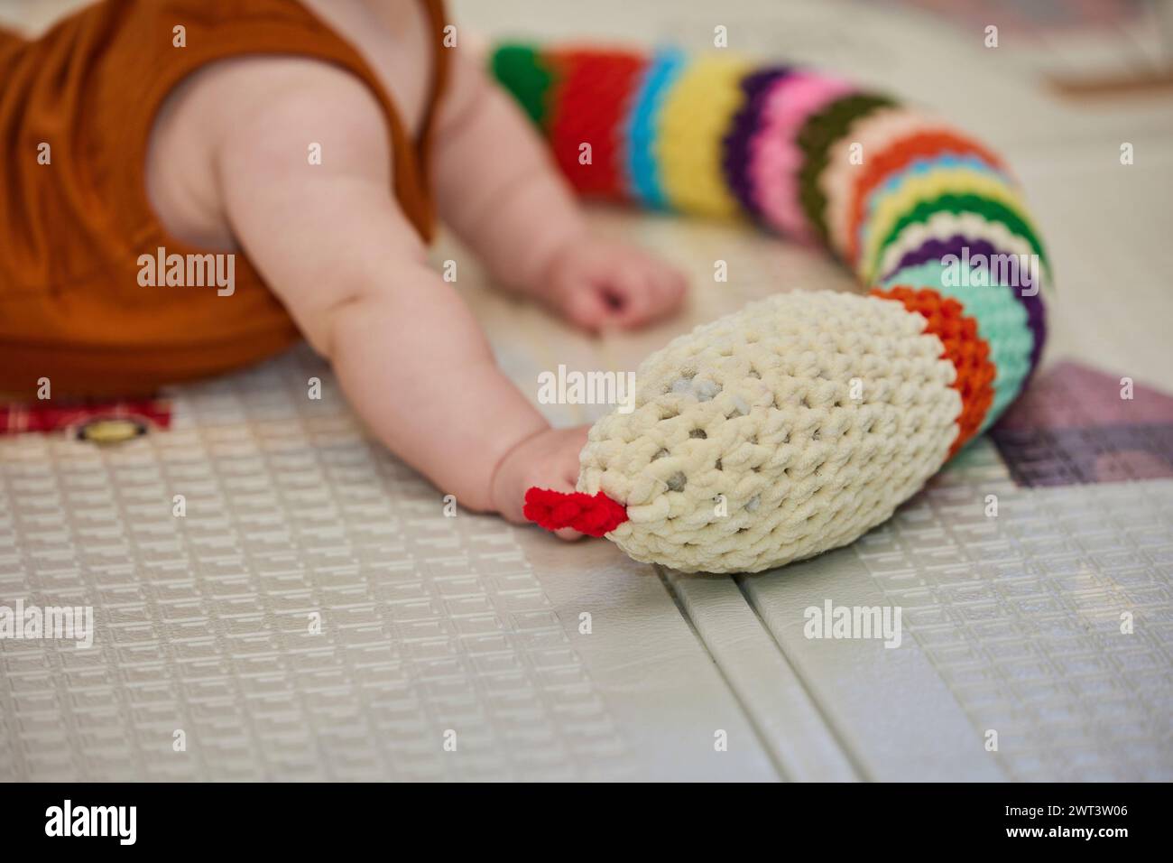 bébé joue avec un jouet tricoté dans la pépinière Banque D'Images
