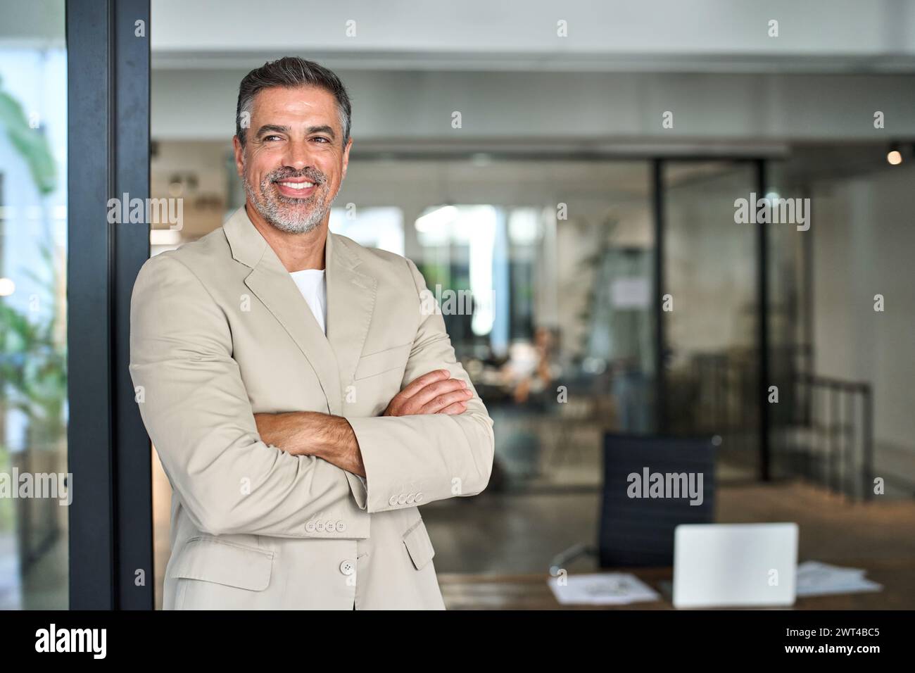 Portrait d'homme d'affaires d'âge moyen heureux confiant regardant loin dans le bureau. Banque D'Images