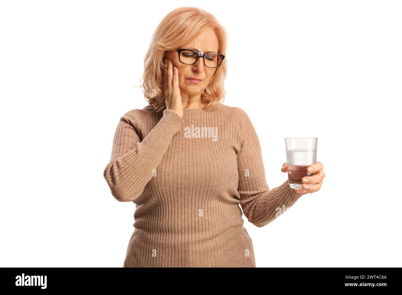 Femme d'âge moyen tenant un verre d'eau et ayant un mal de dents isolé sur fond blanc Banque D'Images