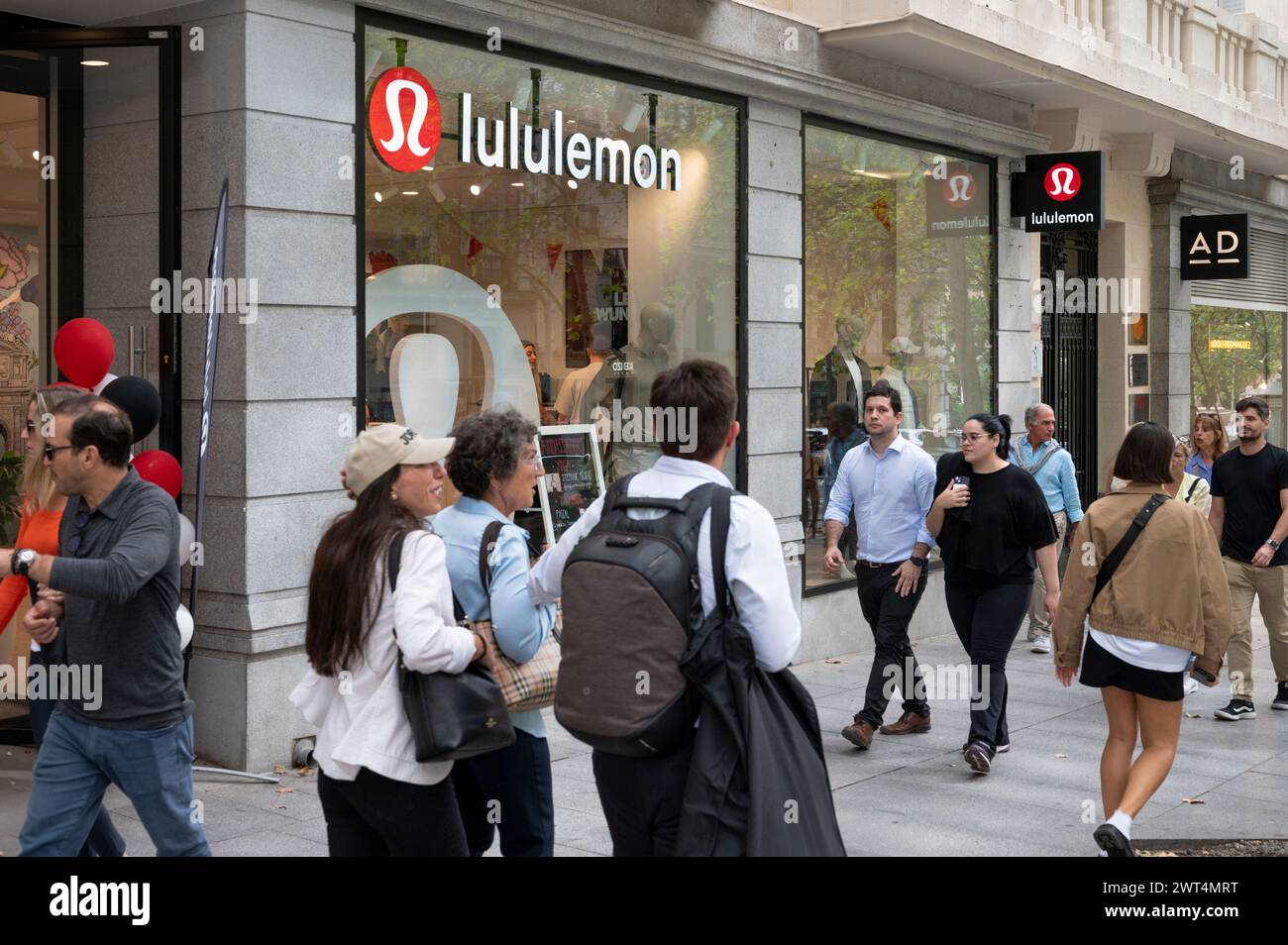 Les acheteurs passent devant le groupe canadien de vêtements de sport, le magasin Lululemon en Espagne. Banque D'Images