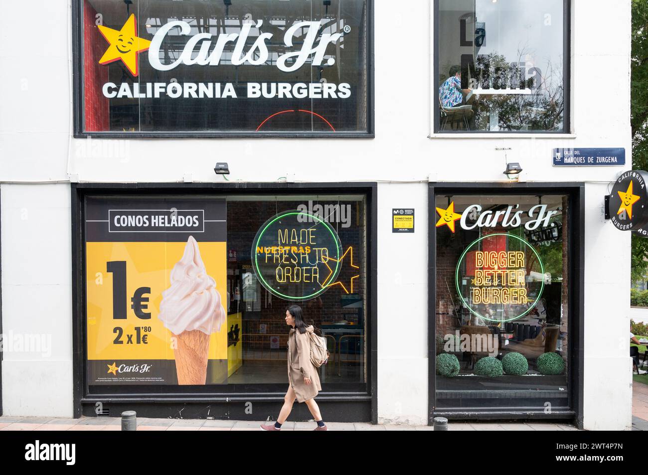 Madrid, Espagne. 15 mars 2024. Une femme passe devant la chaîne de restauration rapide américaine Carl's Jr (Carls Jr) en Espagne. (Photo de Xavi Lopez/SOPA images/Sipa USA) crédit : Sipa USA/Alamy Live News Banque D'Images