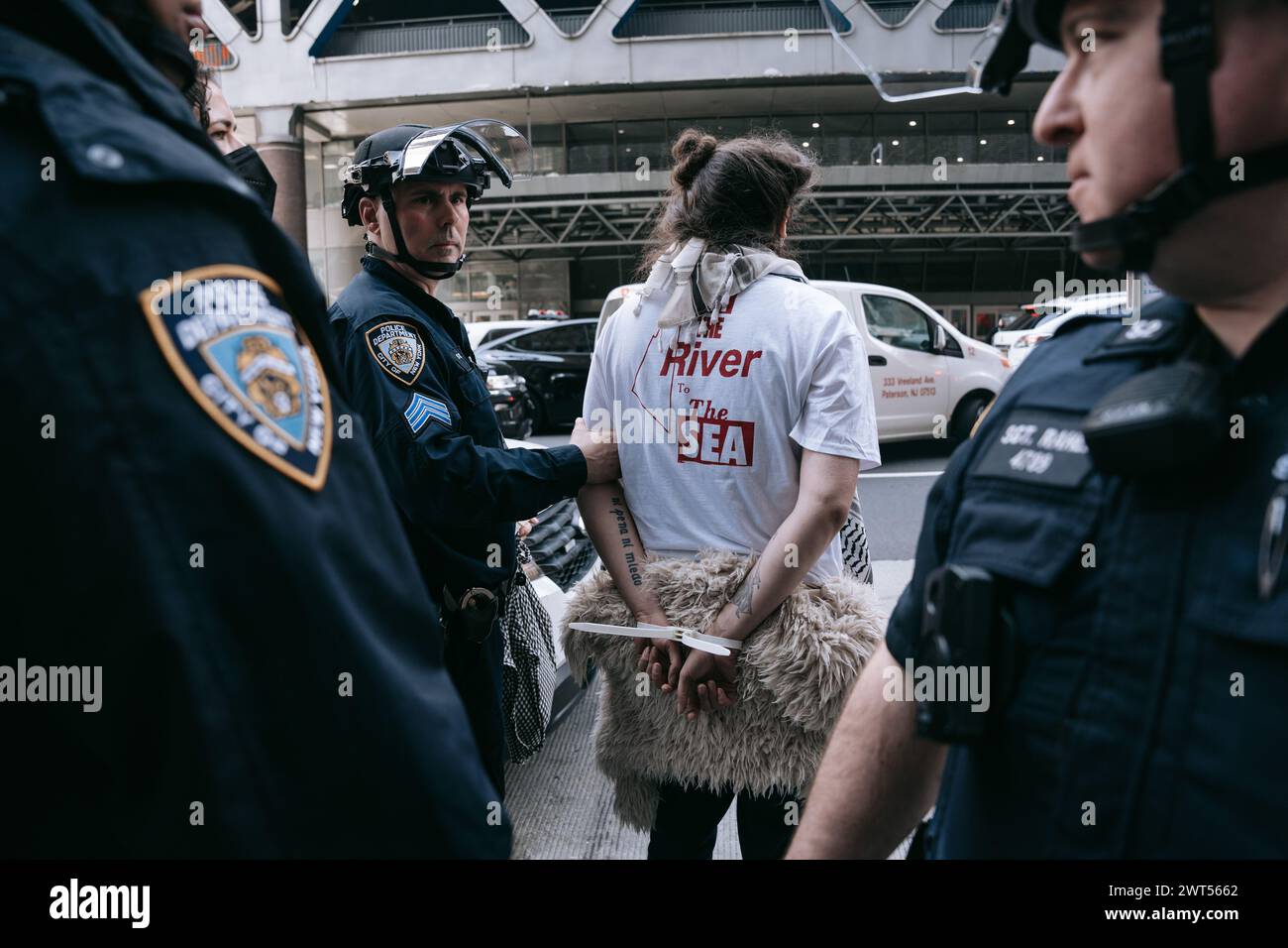 Un manifestant portant un t-shirt avec le slogan « From the River to the Sea » est transporté après avoir été arrêté par des officiers du NYPD en tenue anti-émeute. Plus de 100 manifestants pro-palestiniens ont été arrêtés après avoir pris d'assaut le siège du New York Times et tenté d'empêcher les employés d'accéder à leurs bureaux. Les manifestants, organisés par le mouvement de la jeunesse palestinienne, accusent le journal de faire pencher l'opinion publique en faveur du soutien militaire et financier continu du gouvernement américain à Israël. Banque D'Images