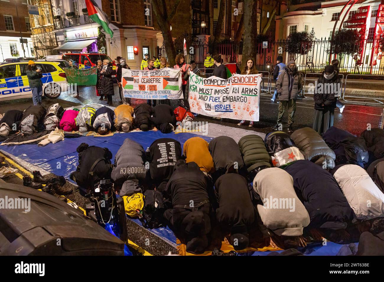 Londres, Royaume-Uni. 15 mars 2024. Des partisans religieux pro-palestiniens sont vus prier devant l'ambassade d'Arabie saoudite à Londres pour la prière Taraweeh. Les partisans pro-palestiniens se rassemblent devant l'ambassade d'Arabie saoudite à Londres pour la prière Taraweeh le 4ème jour du Ramadan pour prier pour ceux qui ont souffert à cause de la guerre Israël-Hamas. Ils condamnent également le gouvernement saoudien pour ne pas avoir fait assez d'efforts pour aider à ramener la paix dans la région. Crédit : SOPA images Limited/Alamy Live News Banque D'Images