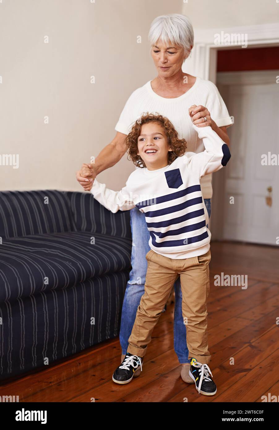 Grand-mère, enfant et jouer dans la maison heureuse, amusement en famille avec l'enfant pour le développement des enfants. Marche, danse et bonheur avec les personnes âgées et Banque D'Images