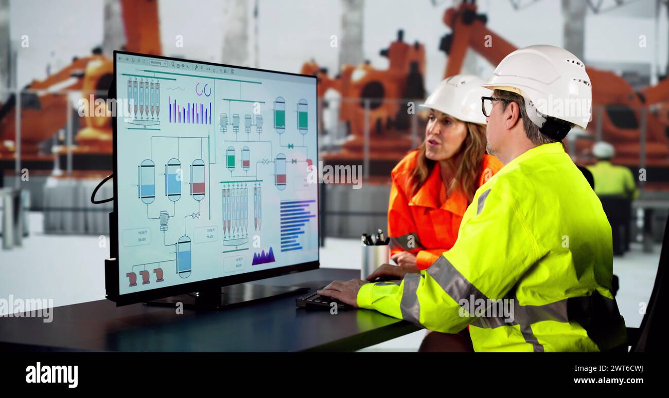 Ingénieur utilisant l'ordinateur dans l'usine d'assemblage de voiture électrique Banque D'Images