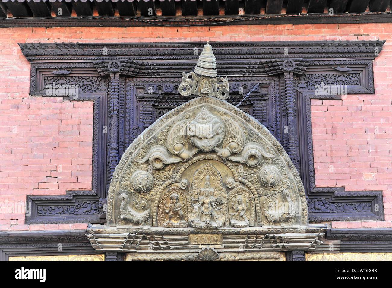 Cadre de porte décoré avec art avec des reliefs et des symboles dans un bâtiment historique, la vallée de Katmandou. Katmandou, Népal Banque D'Images Cadre de porte décoré avec art avec des reliefs et des symboles dans un bâtiment historique, la vallée de Katmandou. Katmandou, Népal Banque D'Images