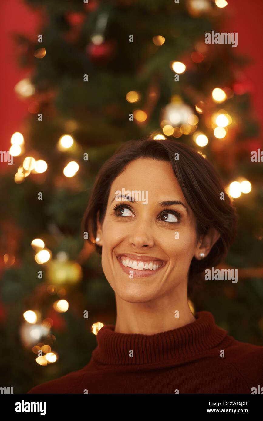 Penser, sourire et Noël avec la femme, la maison et des idées pour la saison des fêtes et la planification de décorations. Personne, appartement et dame avec arbre de Noël Banque D'Images