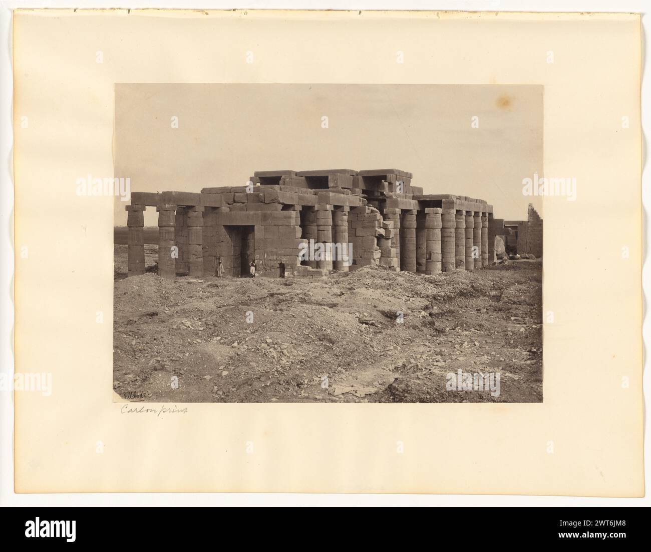 Thèbes : vue générale du Memnonium depuis l'Ouest. Frank Mason Good, photographe (anglais, 1839 - 1928) 1868–1869 vue des ruines du Ramesseum de Thèbes. Deux hommes se tiennent debout sur les côtés opposés d'une grande entrée rectangulaire. Plusieurs colonnes soutiennent les ruines. (Recto, monture) en bas à gauche, crayon : « empreinte carbone » ; (verso, monture) en bas à droite, crayon : '18'; Banque D'Images