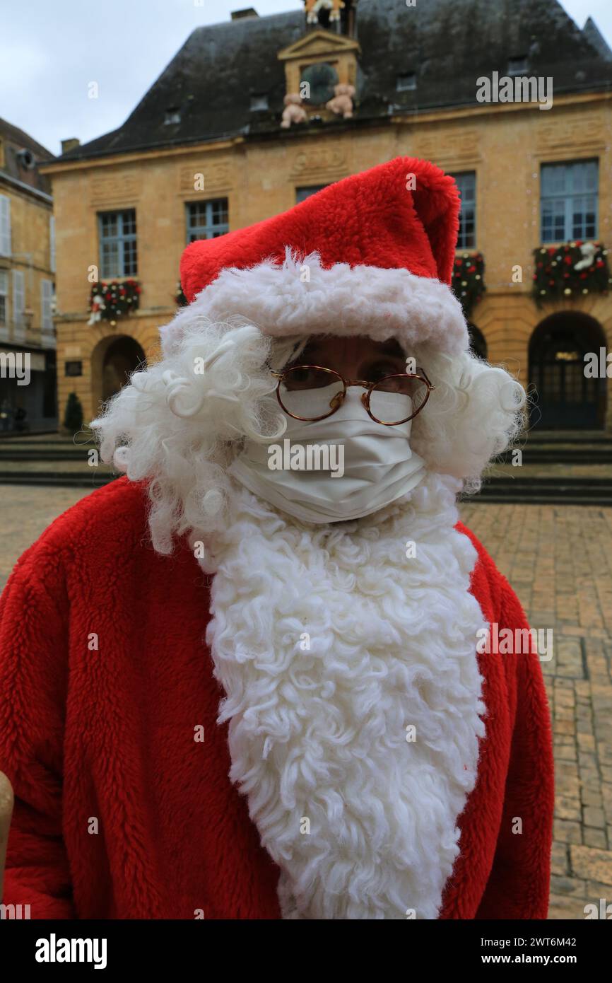 Père Noël et COVID-19. Le Père Noël porte un masque protecteur pendant la pandémie de COVID-19. Sarlat-la-Canéda, Périgord Noir, Dordogne, France, UE Banque D'Images