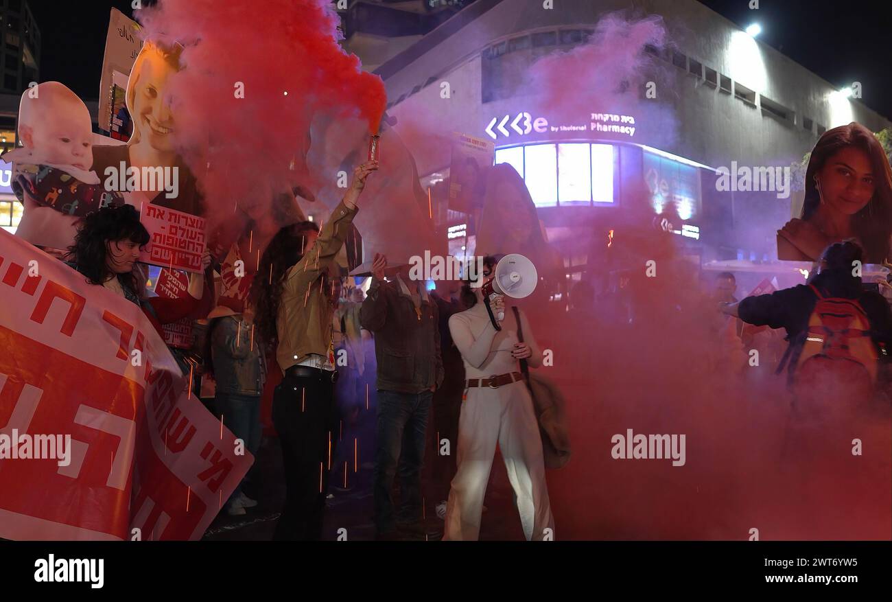 TEL AVIV, ISRAËL - 14 MARS : les familles des otages israéliennes et leurs partisans laissent exploser la fumée rouge en chantant des slogans et en marchant le long de la rue Dizengoff lors d'une manifestation appelant à un accord de cessez-le-feu et au retour des otages, tout en tenant compte des 19 femmes israéliennes qui sont toujours retenues en otage Hamas à Gaza le 14 mars 2024 à tel Aviv, Israël. Banque D'Images TEL AVIV, ISRAËL - 14 MARS : les familles des otages israéliennes et leurs partisans laissent exploser la fumée rouge en chantant des slogans et en marchant le long de la rue Dizengoff lors d'une manifestation appelant à un accord de cessez-le-feu et au retour des otages, tout en tenant compte des 19 femmes israéliennes qui sont toujours retenues en otage Hamas à Gaza le 14 mars 2024 à tel Aviv, Israël. Banque D'Images