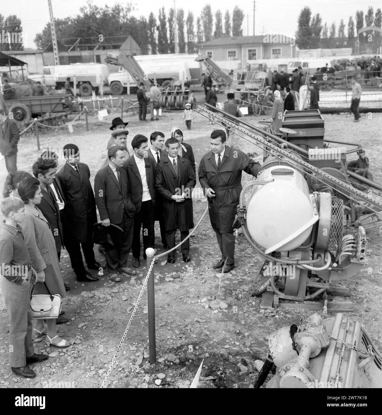 République socialiste de Roumanie, approx. 1976. Diverses machines agricoles exposées lors d'une exposition organisée par le gouvernement. Groupe de personnes écoutant une présentation. Banque D'Images